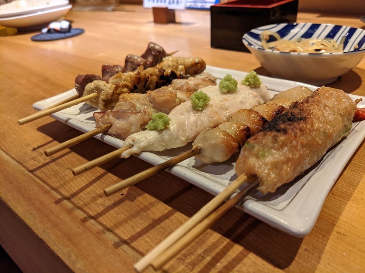 白い長皿に並んだ焼き鳥の串