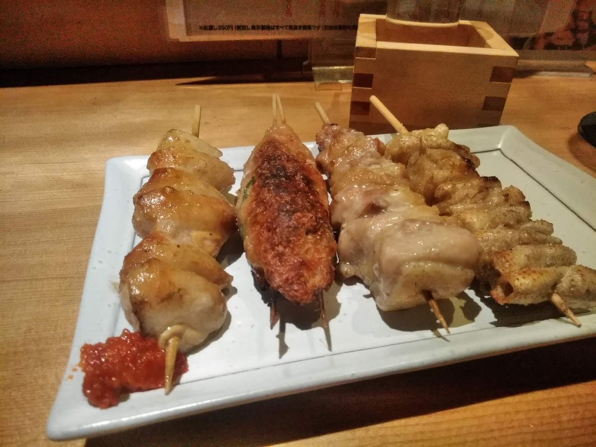 白い皿にのった焼き鳥の串と升